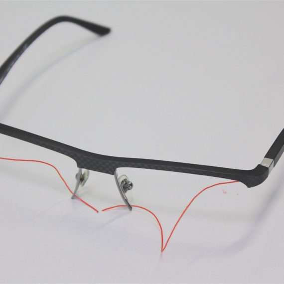 Remplacement d’un fil translucide par un  rouge lors du montage des verres sur ces lunettes Starck.